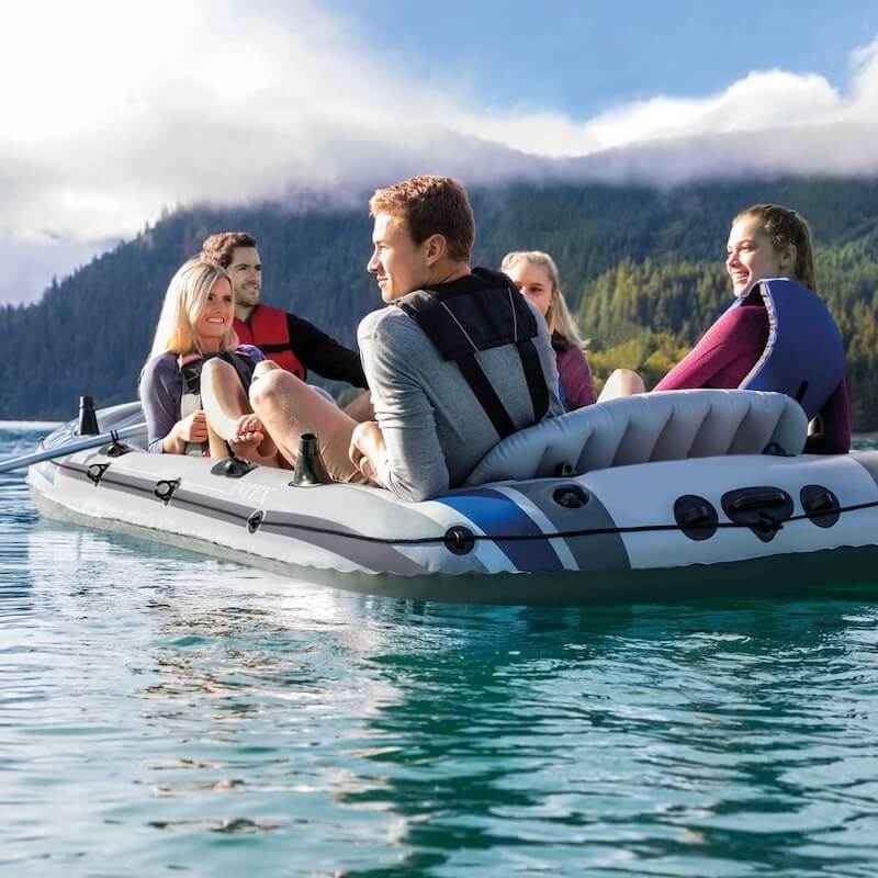 Group of people on an inflatable boat with a scenic mountain background