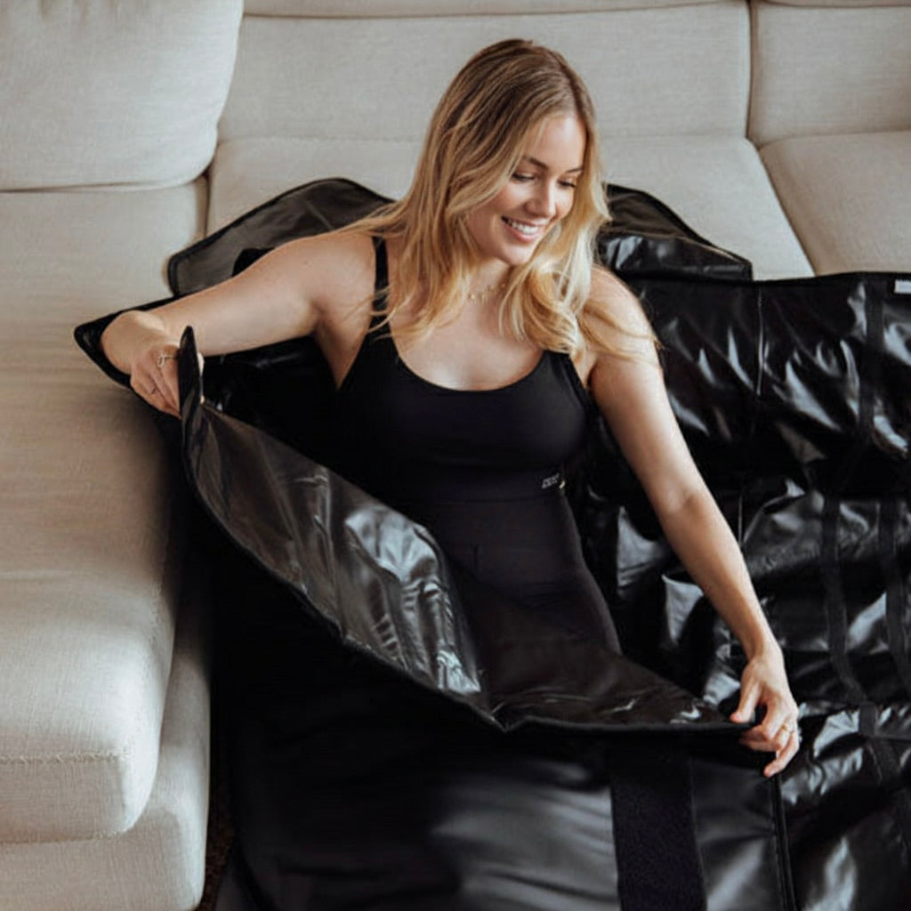 woman inside a black sauna blanket securing it